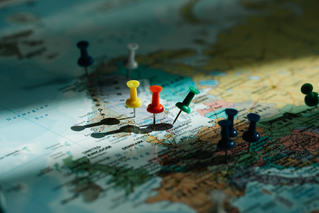 A close-up view of colorful push pins marking locations on a detailed world map.