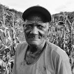 Black and white portrait of a farmer in a cornfield in Brazil.